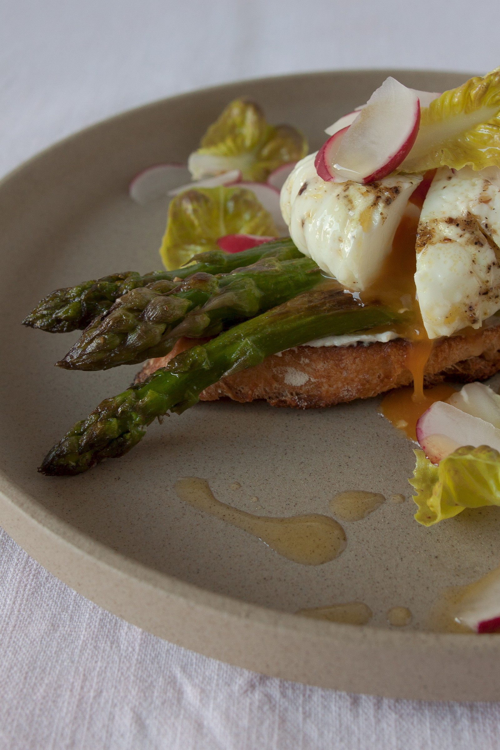 Asparagus crostini with goat cream cheese, poached egg and radishes