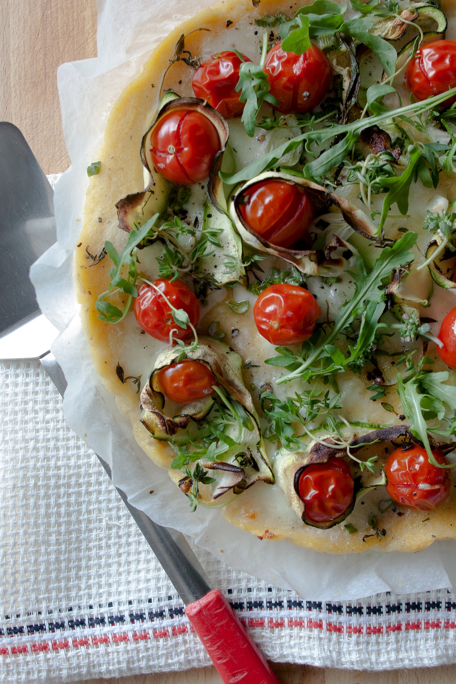 Polenta pizza with zucchini, tomatoes and rocket