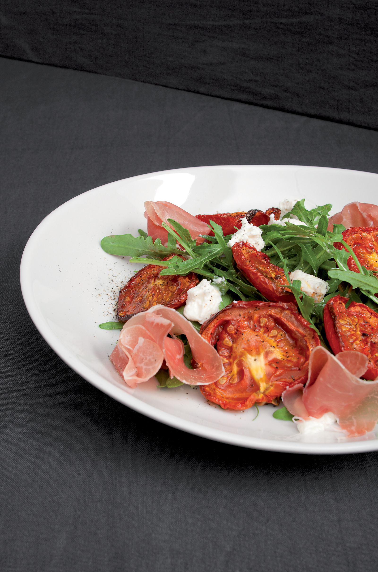Roasted tomatoes with raw ham, ricotta and rocket