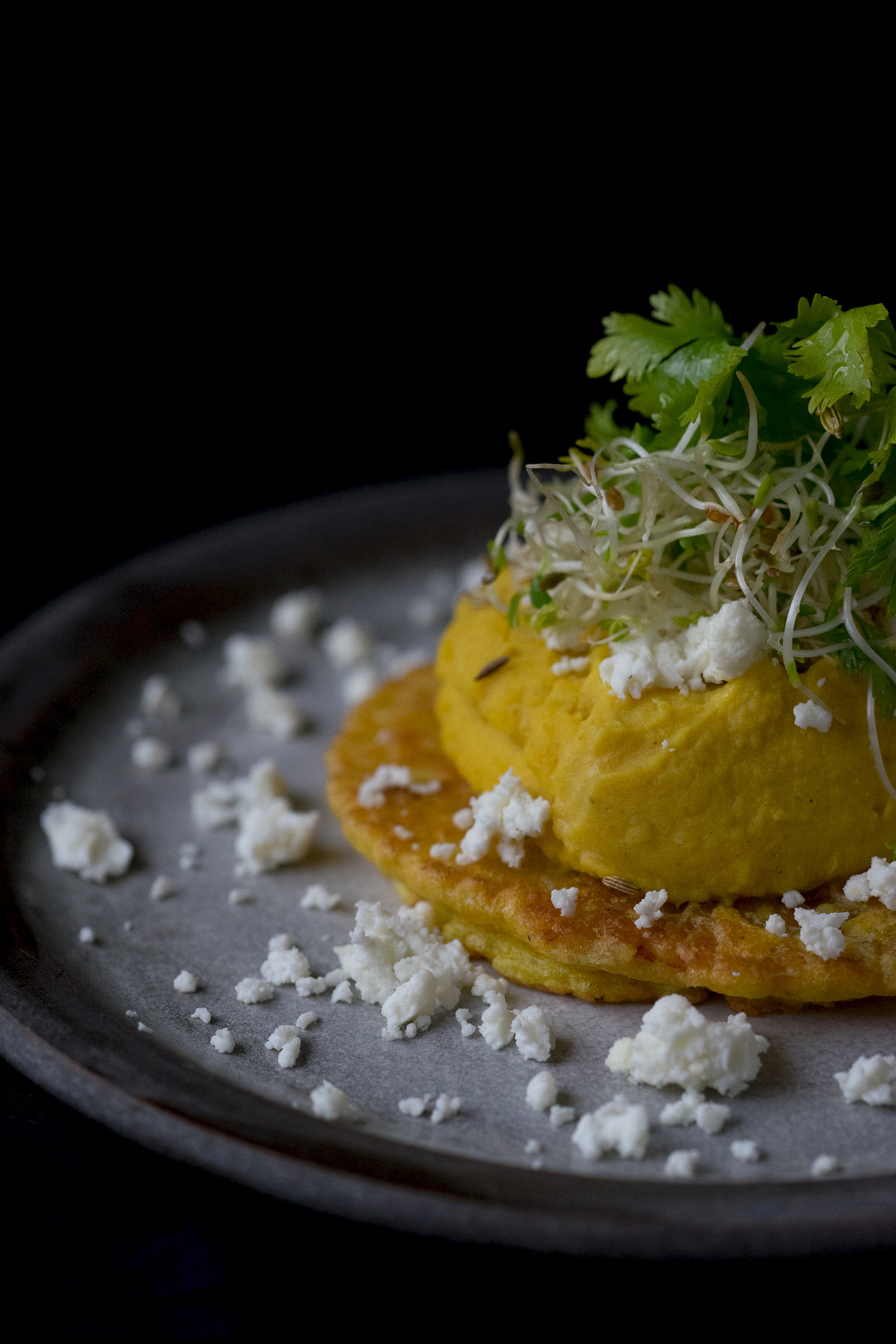 Pumpkin pancakes with hummus and feta