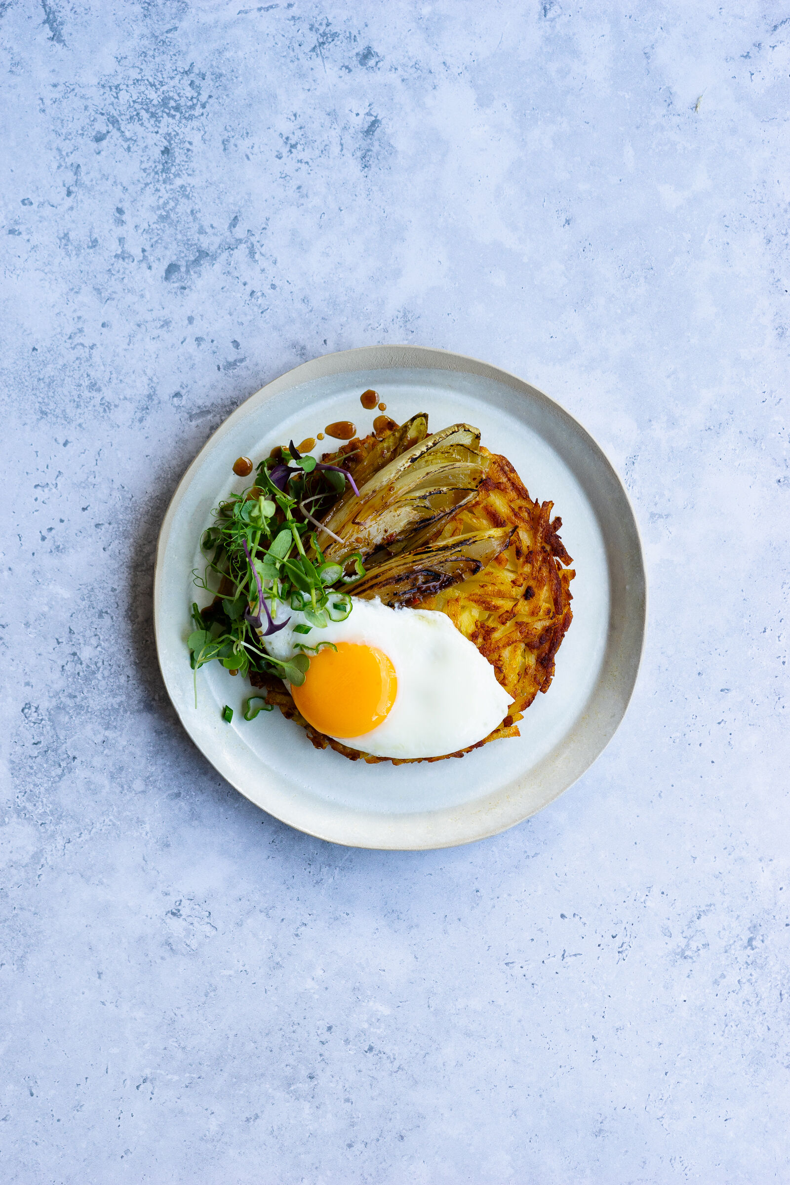 Rösti mit gebratenem Chicorée, Spiegelei und Kresse