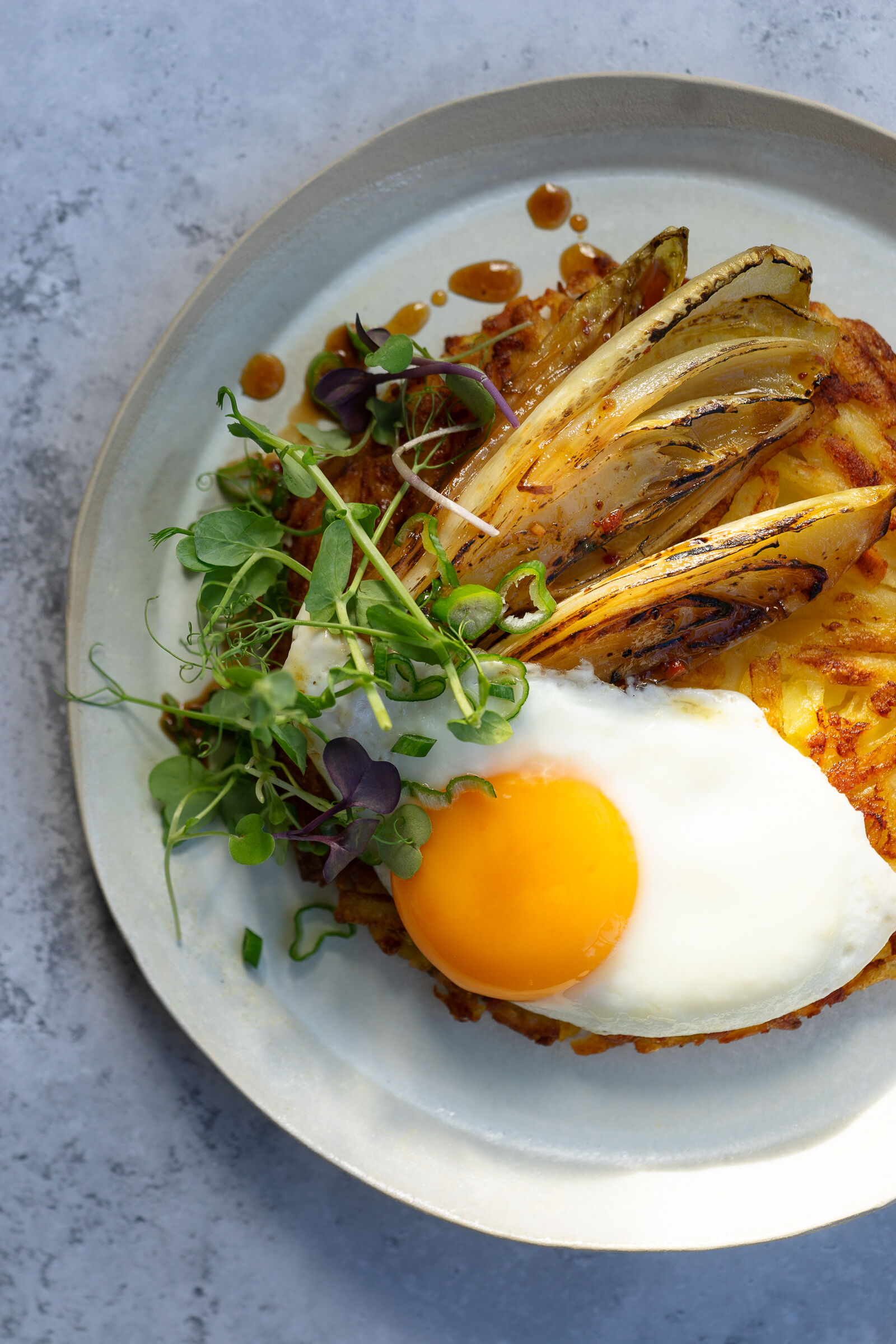 Rösti mit gebratenem Chicorée, Spiegelei und Kresse